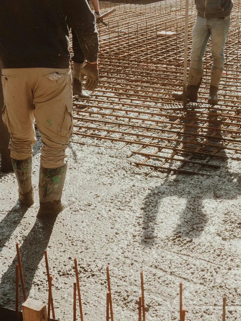 Workers walking across freshly poured concrete